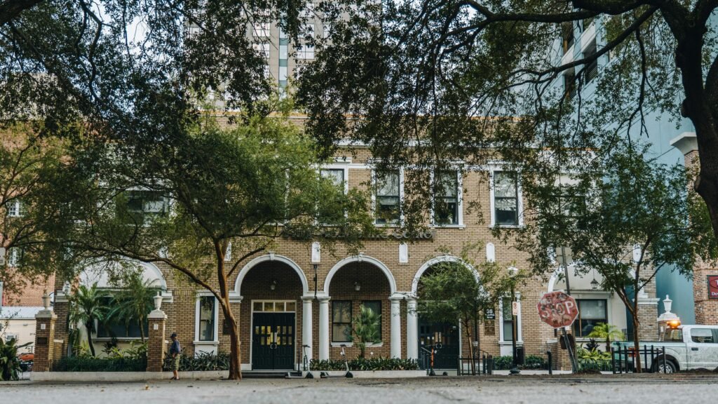 Charming brick building in downtown Orlando surrounded by lush greenery.