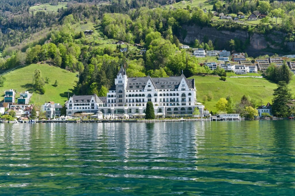 Elegant Swiss hotel by Lake Lucerne surrounded by lush mountains.